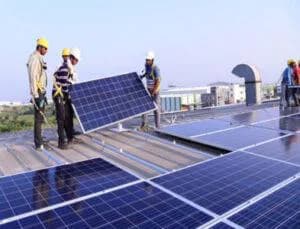 Technicians installing solar panels on a rooftop
